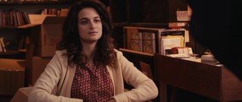 Movie still from “Obvious Child” (2014), directed by Gillian Robespierre – A woman sitting in front of a desk in a room; Close Up shot, Over the shoulder angle