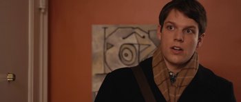 Movie still from “Obvious Child” (2014), directed by Gillian Robespierre – A young man wearing a brown scarf and a brown jacket; Close Up shot, Over the shoulder angle