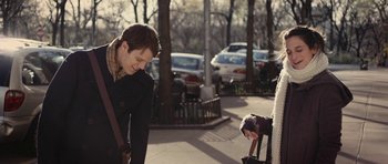 Movie still from “Obvious Child” (2014), directed by Gillian Robespierre – A man standing next to a woman on a sidewalk; Medium shot, Over the shoulder angle