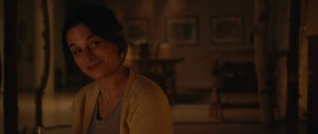 Movie still from “Obvious Child” (2014), directed by Gillian Robespierre – A woman in a yellow jacket smiling for the camera; Close Up shot, Over the shoulder angle