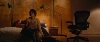 Movie still from “Obvious Child” (2014), directed by Gillian Robespierre – A woman sitting on a chair in a living room; Wide shot, High angle