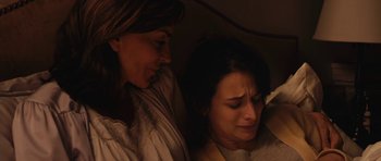 Movie still from “Obvious Child” (2014), directed by Gillian Robespierre – Two women sitting next to each other in a dark room; Close Up shot, High angle