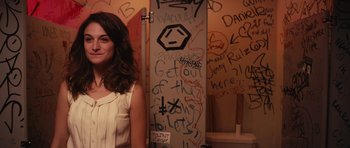 Movie still from “Obvious Child” (2014), directed by Gillian Robespierre – A woman standing in front of a wall covered in graffiti; Medium shot, Over the shoulder angle