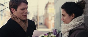 Movie still from “Obvious Child” (2014), directed by Gillian Robespierre – Two people standing on the sidewalk holding flowers; Close Up shot, Over the shoulder angle