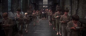 Movie still from “Oliver!” (1968), directed by Carol Reed – A group of young men standing next to each other on a tiled floor; Wide shot, High angle