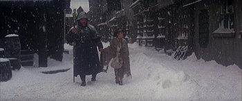 Movie still from “Oliver!” (1968), directed by Carol Reed – A couple of people walking through the snow; Wide shot, High angle