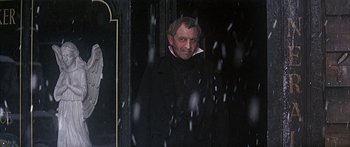 Movie still from “Oliver!” (1968), directed by Carol Reed – A man standing in front of a mirror in the snow; Medium shot, Low angle