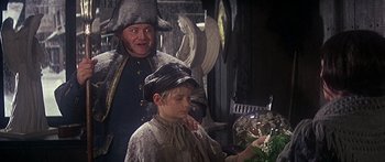 Movie still from “Oliver!” (1968), directed by Carol Reed – A man and a boy dressed in medieval clothing; Medium shot, High angle