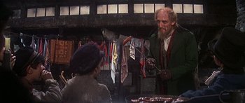 Movie still from “Oliver!” (1968), directed by Carol Reed – An old man with a long white beard talking to a young woman; Medium shot, Over the shoulder angle