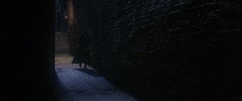 Movie still from “Oliver!” (1968), directed by Carol Reed – Two people are walking on a snowy path at night; Extreme Wide shot, Over the shoulder angle