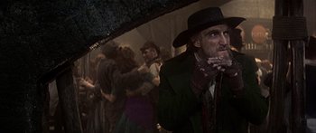 Movie still from “Oliver!” (1968), directed by Carol Reed – An old man in a hat and a black hat holding an umbrella; Close Up shot, Low angle