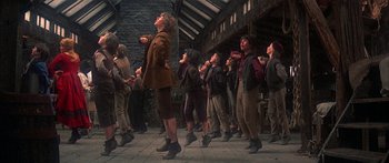 Movie still from “Oliver!” (1968), directed by Carol Reed – A group of people standing in a line; Wide shot, Low angle