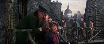 Movie still from “Oliver!” (1968), directed by Carol Reed – A group of people standing next to each other on steps; Medium shot, Low angle