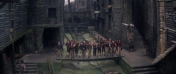 Movie still from “Oliver!” (1968), directed by Carol Reed – A group of people standing next to each other on top of a bridge; Wide shot, High angle