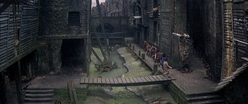 Movie still from “Oliver!” (1968), directed by Carol Reed – A group of people standing on a bridge over a river; Extreme Wide shot, High angle