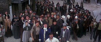 Movie still from “Oliver!” (1968), directed by Carol Reed – A large group of people wearing hats and gloves; Wide shot, High angle