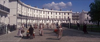 Movie still from “Oliver!” (1968), directed by Carol Reed – A group of people walking in front of a large building; Extreme Wide shot, High angle