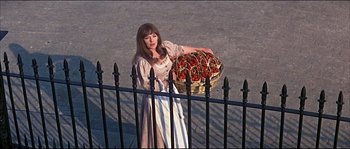 Movie still from “Oliver!” (1968), directed by Carol Reed – A woman holding a basket full of tomatoes; Medium shot, High angle