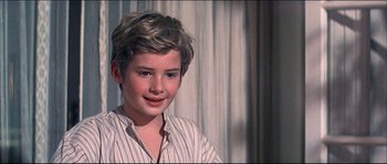 Movie still from “Oliver!” (1968), directed by Carol Reed – A young boy is smiling for the camera; Close Up shot, High angle