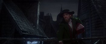 Movie still from “Oliver!” (1968), directed by Carol Reed – A man with a beard wearing a green jacket and a hat; Medium shot, Low angle