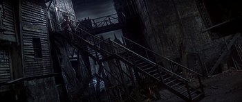 Movie still from “Oliver!” (1968), directed by Carol Reed – Some stairs going up to the top of a tall building; Extreme Wide shot, High angle