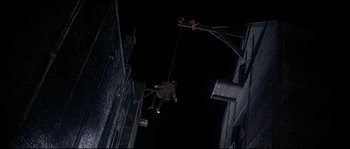 Movie still from “Oliver!” (1968), directed by Carol Reed – A man hanging from a rope while another man watches from below; Wide shot, Overhead angle