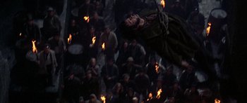 Movie still from “Oliver!” (1968), directed by Carol Reed – A man hanging from a rope in front of a crowd of onlookers; Wide shot, Overhead angle