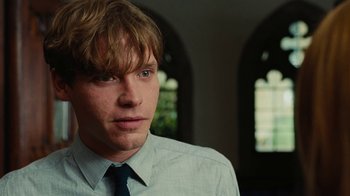 Movie still from “On Chesil Beach” (2017), directed by Dominic Cooke – A young man wearing a dress shirt and a tie; Close Up shot, Over the shoulder angle