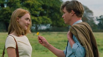 Movie still from “On Chesil Beach” (2017), directed by Dominic Cooke – A man holding a flower in his hand while a woman looks at him; Close Up shot, Over the shoulder angle