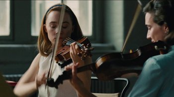 Movie still from “On Chesil Beach” (2017), directed by Dominic Cooke – A woman is playing the violin in a room; Close Up shot, Low angle