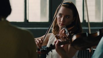 Movie still from “On Chesil Beach” (2017), directed by Dominic Cooke – A woman is playing the violin in a room; Close Up shot, Over the shoulder angle