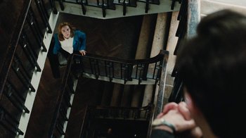 Movie still from “On Chesil Beach” (2017), directed by Dominic Cooke – A woman standing at the top of a set of stairs; Wide shot, Overhead angle