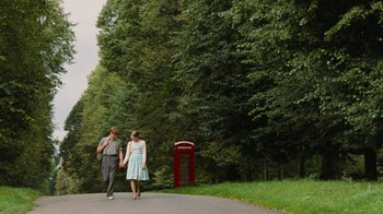 Movie still from “On Chesil Beach” (2017), directed by Dominic Cooke – A man and a woman walking down a road; Wide shot, Low angle