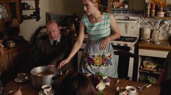 Movie still from “On Chesil Beach” (2017), directed by Dominic Cooke – A man and a woman are cooking in a kitchen; Medium shot, Over the shoulder angle