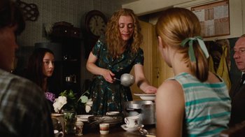Movie still from “On Chesil Beach” (2017), directed by Dominic Cooke – A woman pouring tea into a tea pot on a table; Medium shot, Over the shoulder angle