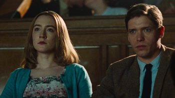 Movie still from “On Chesil Beach” (2017), directed by Dominic Cooke – A man and a woman sitting next to each other in a courtroom; Close Up shot, Low angle