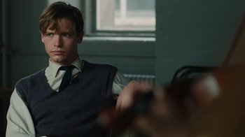 Movie still from “On Chesil Beach” (2017), directed by Dominic Cooke – A man in a vest and tie sitting in front of a camera; Close Up shot, Over the shoulder angle