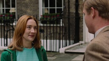 Movie still from “On Chesil Beach” (2017), directed by Dominic Cooke – Two people standing on a sidewalk near each other; Close Up shot, Over the shoulder angle