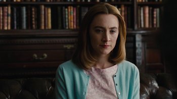 Movie still from “On Chesil Beach” (2017), directed by Dominic Cooke – A woman sitting in front of a bookshelf in a room; Close Up shot, Over the shoulder angle