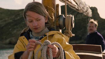 Movie still from “On Chesil Beach” (2017), directed by Dominic Cooke – A girl in a yellow jacket holding a rope; Medium shot, Low angle
