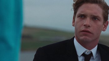 Movie still from “On Chesil Beach” (2017), directed by Dominic Cooke – A person wearing a suit and tie; Close Up shot, Over the shoulder angle