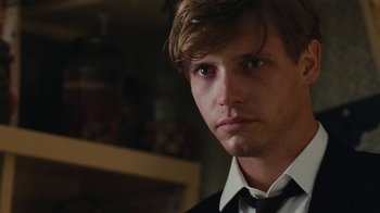 Movie still from “On Chesil Beach” (2017), directed by Dominic Cooke – A man in a suit and tie looking at the camera; Close Up shot, Over the shoulder angle