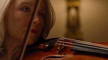 Movie still from “On Chesil Beach” (2017), directed by Dominic Cooke – A person holding a violin; Extreme Close Up shot, Low angle