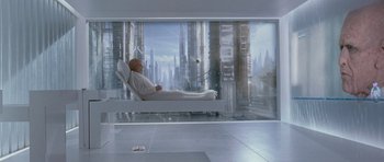 Movie still from “Mr. Nobody” (2009), directed by Jaco Van Dormael – A man sitting in a chair in a room with a view of a city; Wide shot, High angle