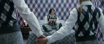 Movie still from “Mr. Nobody” (2009), directed by Jaco Van Dormael – A person sitting on a bed holding a cell phone; Medium shot, High angle