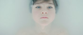 Movie still from “Mr. Nobody” (2009), directed by Jaco Van Dormael – A young girl with blue eyes looking at the camera; Extreme Close Up shot, Overhead angle