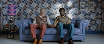 Movie still from “Mr. Nobody” (2009), directed by Jaco Van Dormael – A couple of men sitting on top of a blue couch; Medium shot, Overhead angle
