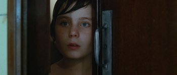 Movie still from “Mr. Nobody” (2009), directed by Jaco Van Dormael – A young child looking out a door way; Close Up shot, Over the shoulder angle