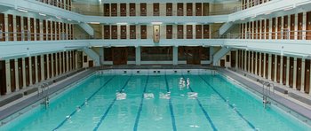 Movie still from “Mr. Nobody” (2009), directed by Jaco Van Dormael – An indoor swimming pool with a view of the inside of the building; Extreme Wide shot, Overhead angle