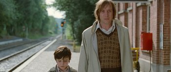 Movie still from “Mr. Nobody” (2009), directed by Jaco Van Dormael – A man and a boy walking down a street; Medium shot, Low angle